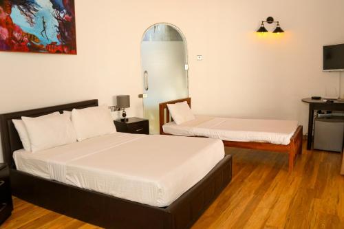 a bedroom with two beds and a tv in it at The Blue Lagoon Resort Kalpitiya in Kalpitiya