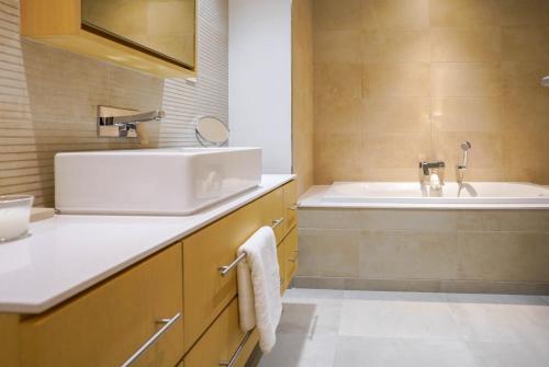 a bathroom with a sink and a bath tub at Primestay - Belgravia in JVC in Dubai