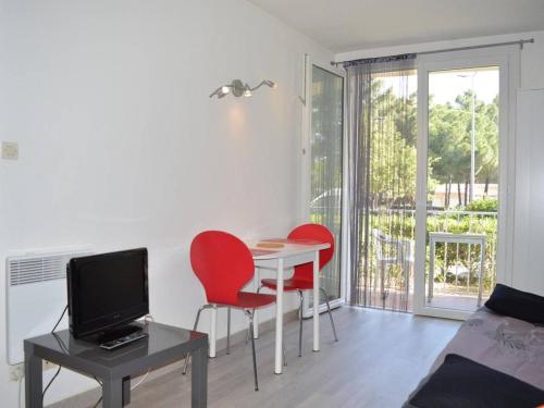 - un salon avec une table et deux chaises rouges dans l'établissement Appartement Argelès-sur-Mer, 1 pièce, 2 personnes - FR-1-225-235, à Argelès-sur-Mer