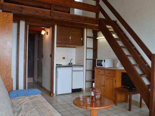 une cuisine avec un escalier et une table. dans l'établissement Studio avec mezzanine pour 5, proche plage, animaux acceptés - Saint Pierre la Mer - FR-1-229D-222, à Saint Pierre La Mer
