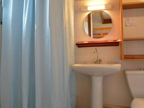 La salle de bains est pourvue d'un lavabo, d'un miroir et d'un rideau de douche. dans l'établissement Studio avec mezzanine pour 5, proche plage, animaux acceptés - Saint Pierre la Mer - FR-1-229D-222, à Saint Pierre La Mer