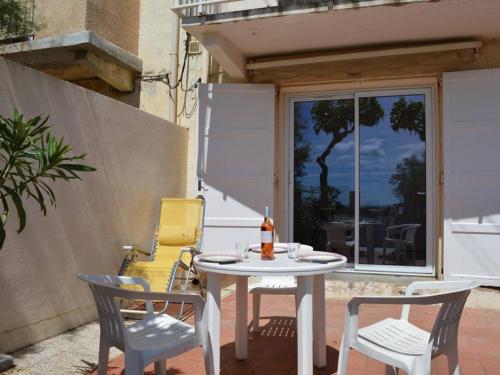 une table et des chaises assises sur une terrasse dans l'établissement Appartement 3 pièces avec terrasse, calme, proche plage et commerces, 2 étoiles Meublé de Tourisme - FR-1-229D-214, à Saint Pierre La Mer