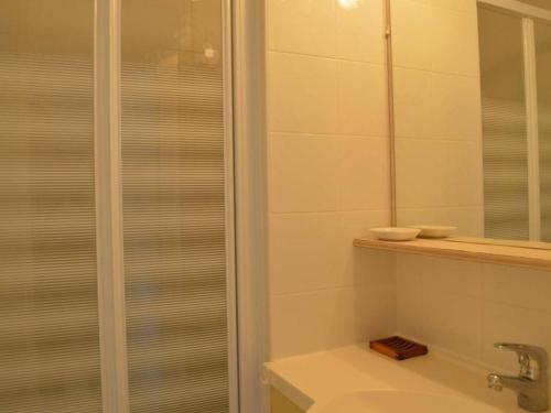 une salle de bain avec une douche, un lavabo et un miroir dans l'établissement Appartement 3 pièces avec terrasse, calme, proche plage et commerces, 2 étoiles Meublé de Tourisme - FR-1-229D-214, à Saint Pierre La Mer