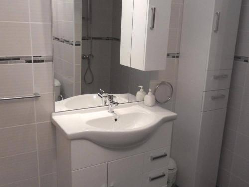 La salle de bains blanche est pourvue d'un lavabo et d'un miroir. dans l'établissement Maison Port-la-Nouvelle, 3 pièces, 6 personnes - FR-1-229C-382, à Port-la-Nouvelle