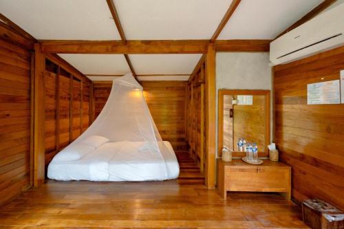 a bed in a room with wooden walls at Jungle Koh Kood Resort in Ko Kood