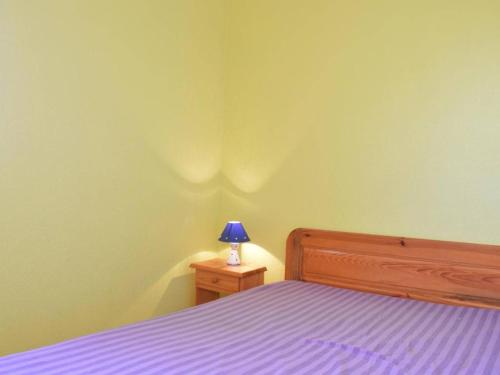 a bedroom with a bed with a blue lamp on a night stand at Appartement Fleury-Saint-Pierre-la-Mer, 2 pièces, 4 personnes - FR-1-229D-280 in Saint Pierre La Mer