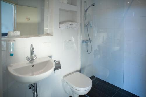 a bathroom with a sink and a toilet and a shower at Hotel Grand Cafe Deight in Zandvoort