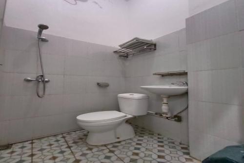 a bathroom with a toilet and a sink at OYO 92207 Hotel Koperasi in Banda Aceh