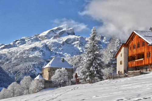 a building in the snow next to a mountain at Residence Sas Vanna in La Villa