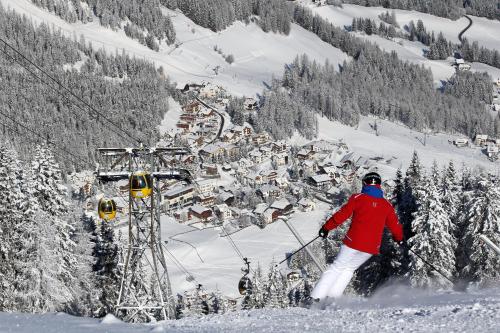 a man riding a ski lift on a snow covered mountain at Residence Sas Vanna in La Villa