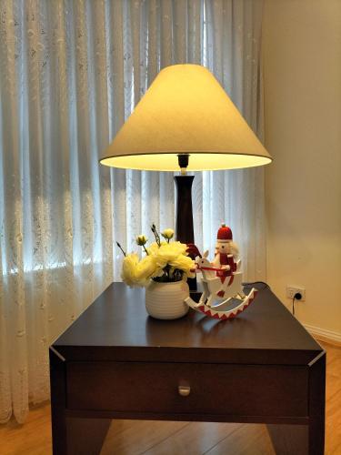 a lamp on a table with flowers and a snowman on it at 12 mins to Mel Airport-Good Wood House in St Albans