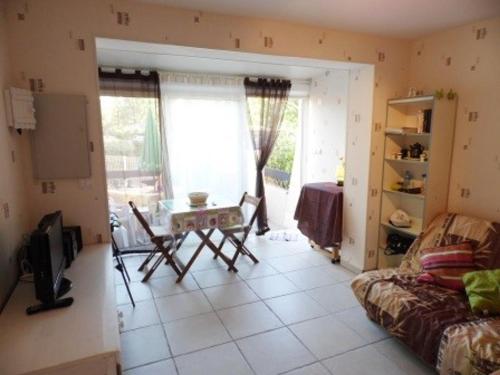 un salon avec une table et un canapé dans l'établissement Appartement T2 avec Terrasse et Parking Privé à Marseillan, Animaux Admis - FR-1-326-486, à Marseillan