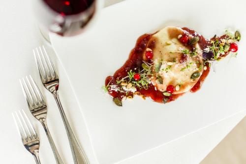 a plate of food on a table with two forks at Astor Hotel in Schenna