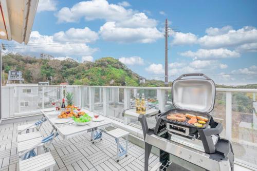 a grill on a balcony with a table with food on it at ふくろう庵-白浜- in Shirahama