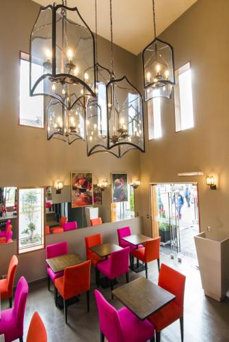 a restaurant with colorful chairs and tables and chandeliers at Atiq Boutique Hotel in Cusco