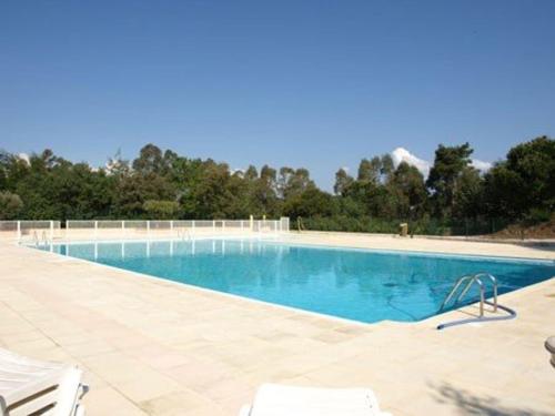 - une piscine avec de l'eau bleue et des chaises blanches dans l'établissement Mas avec 3 chambres, jardin, piscine, tennis et proche plage à La Croix-Valmer - FR-1-100-152, à La Croix-Valmer