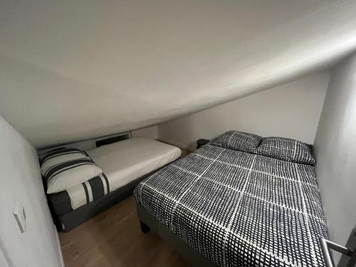 um pequeno quarto com uma cama num pequeno quarto em Chez Polo em Saint-Denis
