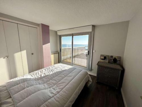 une chambre avec un lit et une grande fenêtre dans l'établissement Quiberon - Appartement 2 pièces, terrasse, animaux permis, parking - FR-1-478-54, à Quiberon