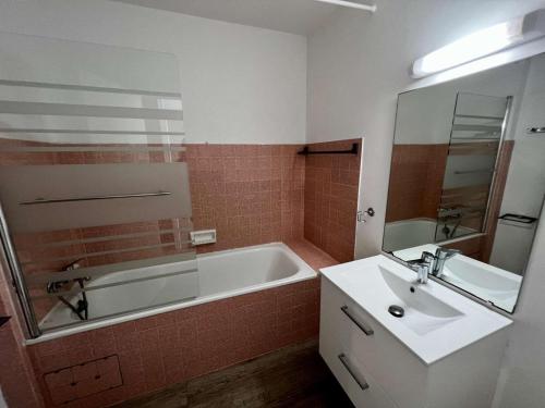 ein Badezimmer mit einer Badewanne und einem Waschbecken in der Unterkunft Studio Quiberon, 1 pièce, 2 personnes - FR-1-478-111 in Quiberon