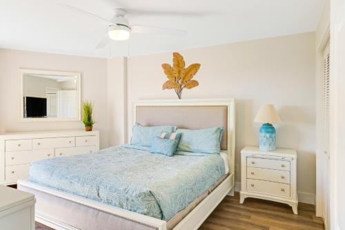 um quarto branco com uma cama e um espelho em Nauti Hideaway, Unit #2314 em Tavernier