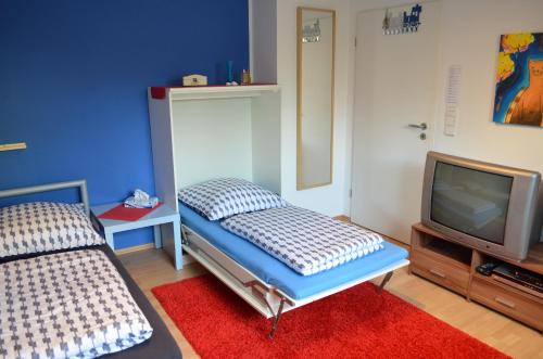 sypialnia z łóżkiem i telewizorem w obiekcie Quartier Ostheim w Kolonii