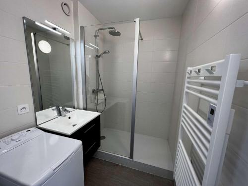 une salle de bain blanche avec une douche et un lavabo dans l'établissement Studio rénové à Quiberon, parking et vue mer - FR-1-478-137, à Quiberon