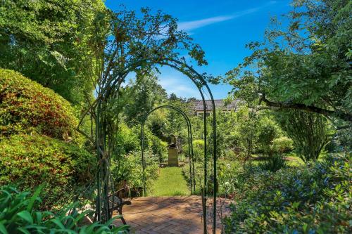 a garden with an archway in a garden at Carcoola in Blackheath