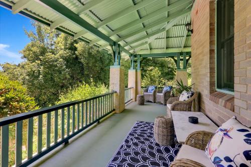 a porch with chairs and tables on a balcony at Carcoola in Blackheath