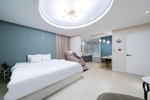 ein Schlafzimmer mit einem großen weißen Bett in einem Zimmer in der Unterkunft KNox Hotel in Cheonan