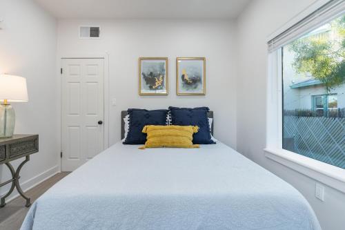 a bedroom with a bed with a yellow pillow on it at Fresh bungalow next to UArizona! in Tucson