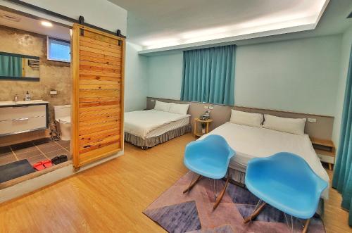 a bedroom with two beds and a table and two chairs at A Promised Land BnB in Jiufen
