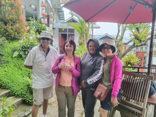 a group of four people standing under an umbrella at Bintang Bungalow Tour & Travel in Kelimutu