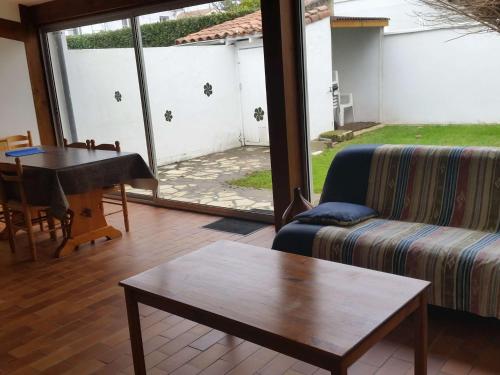 un salon avec un canapé et une table dans l'établissement Maison au calme 2 ch. avec jardin privé proche plage et commerces, idéal pour 4 pers. - FR-1-494-57, à Royan