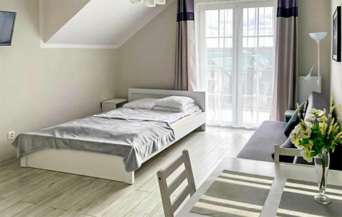 a white bedroom with a bed and a window at Amazing Apartment In Karwia With Heated Swimming Pool in Karwia