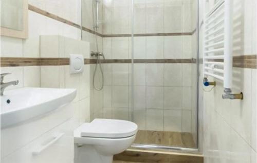 a bathroom with a toilet and a sink and a shower at Amazing Apartment In Karwia With Heated Swimming Pool in Karwia