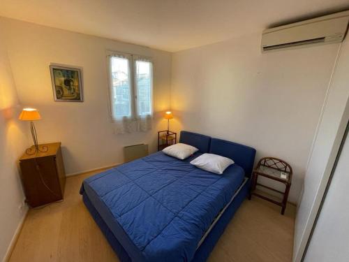 ein Schlafzimmer mit einem blauen Bett in einem Zimmer in der Unterkunft Appartement Capbreton, 2 pièces, 4 personnes - FR-1-413-101 in Capbreton