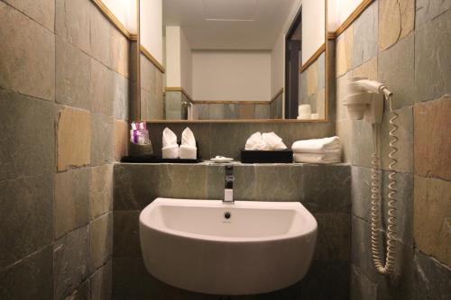 a bathroom with a sink and a mirror at de King Hotel KLCC in Kuala Lumpur