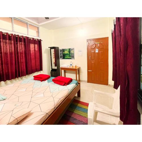 a bedroom with a bed with two red pillows on it at Cupidtrails Backpacker's Penthouse in Guwahati
