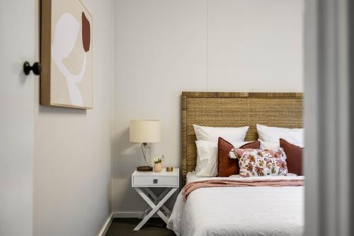 a bedroom with a bed and a table with a lamp at Cute & Cheerful! Close to CBD & Gorgeous Parkland! in Toowoomba