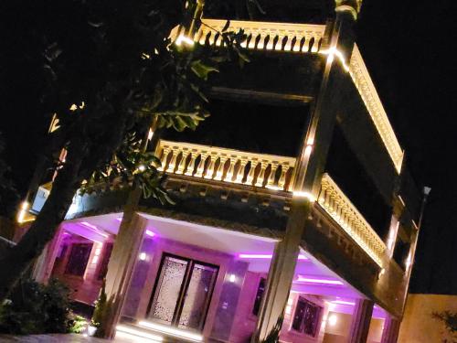 a building with purple lights on it at night at مون لايت Moon Light Villa in ‘Ezbet Sa‘dî Mugâwir