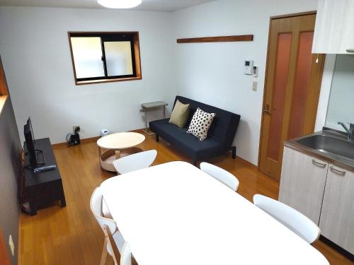a living room with a couch and a table at ブルーセレスト数山 in Numazu