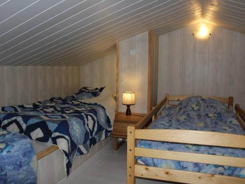 une chambre avec deux lits et une lampe sur une table dans l'établissement Appartement T2 - Mezzanine 5 couchages avec piscine et parking - FR-1-229D-58, à Fleury