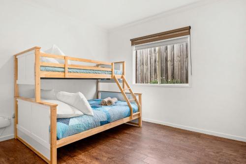 a bedroom with a bunk bed and a window at Shallow Water Retreat in Cowes