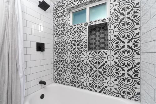 a black and white bathroom with a tub and a window at Fresh bungalow next to UArizona! in Tucson