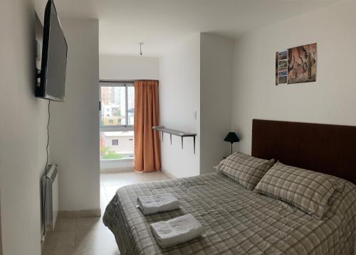 1 dormitorio con 1 cama y TV de pantalla plana en A&B Apartment en Salta