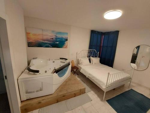 ein Schlafzimmer mit einer Badewanne und einem Bett mit einem Spiegel in der Unterkunft apartment with sea view- itallian jaccuzi in Netanya