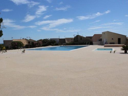 une grande piscine au milieu d'un parking dans l'établissement Appartement RDC 2 pièces+cabine, piscine, terrasse, parking privé - Saint Pierre La Mer - FR-1-229D-71, à Fleury
