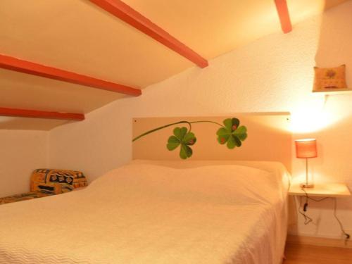une chambre avec un lit blanc avec un trèfle à quatre feuilles peint dessus dans l'établissement Maison familiale climatisée, 6 couchages, proche plage et centre, terrasse, parking privé - FR-1-229D-79, à Fleury