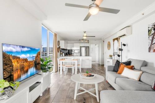 a living room with a couch and a tv at Spacious Inner city Apartment with free parking in Brisbane