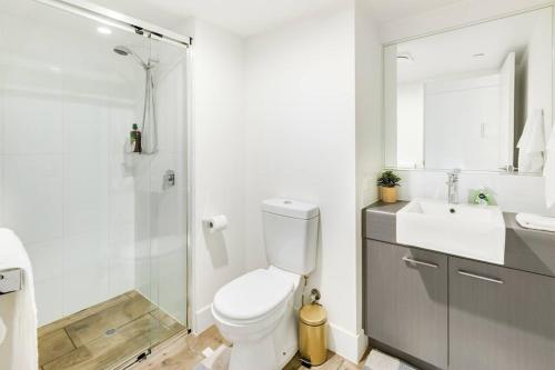 a bathroom with a toilet and a sink and a shower at Spacious Inner city Apartment in Brisbane